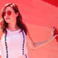 woman wearing subtle floral top against a red background